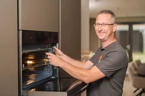 Vakman die een oven installeert